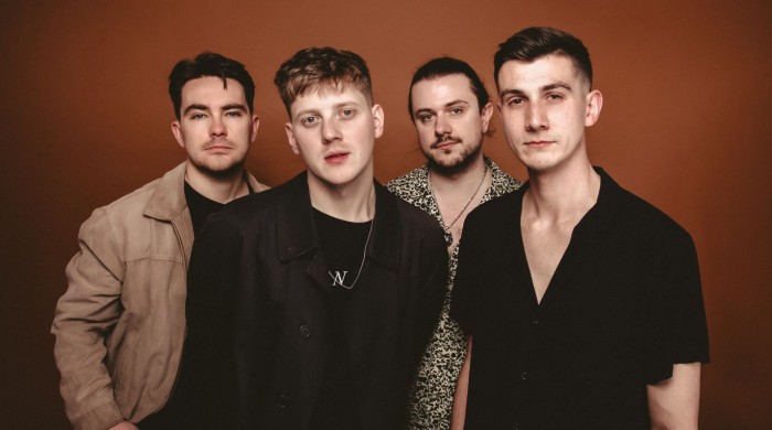 Four men stood in front of a red backdrop